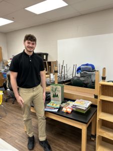 A boy poses with books