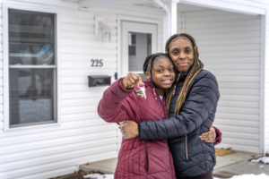 A mom and daughter in front of a house